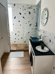 a bathroom with a sink and a washing machine at Falcon Apartman Tatabánya in Tatabánya +13 photos