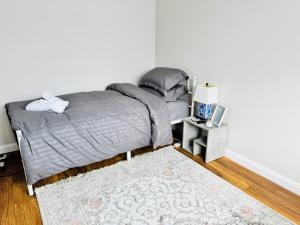 une chambre avec un lit avec une couette grise et un tapis dans l'établissement Quiet Family House, à Brookwood