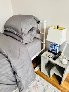 - une chambre avec un lit et une table de chevet avec une lampe dans l'établissement Quiet Family House, à Brookwood