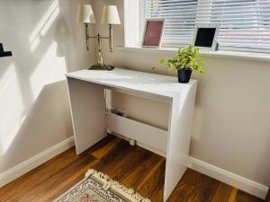 - un bureau blanc dans une chambre avec fenêtre dans l'établissement Quiet Family House, à Brookwood