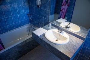 a bathroom with two sinks and a bath tub at Auberge le Cévenol in La Cavalerie +34 photos