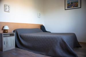 a bedroom with a bed and a table with a lamp at Auberge le Cévenol in La Cavalerie