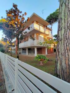 a white fence in front of a house at Il Villino Lido Spina in Lido di Spina