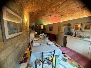 a kitchen with a table with chairs and a kitchen with at Corte Arancio your home in the heart of Monferrato in Cella Monte