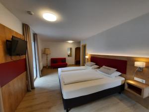 a hotel room with two beds and a television at Pension Alter Wirt in Enkering