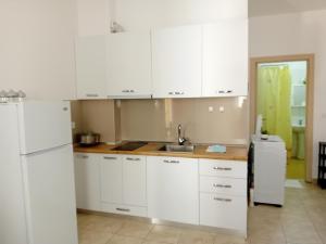 a kitchen with white cabinets and a white refrigerator at Marjana's Apartment 4 in Lezhë