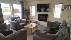 a living room with two couches and a tv at Coastal Retreat Lodge in Morecambe