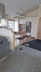 een keuken met een tafel en 2 barkrukken bij Coastal Retreat Lodge in Morecambe +12 foto's