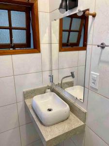 a bathroom with a white sink and a mirror at Ap da Serra em Barão de Javary in Miguel Pereira +32 photos