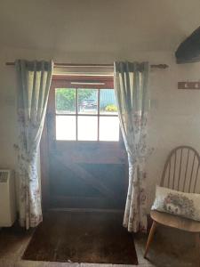 a room with a door and a window and a chair at Captains Cottage Dover in Wootton +5 photos