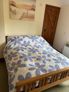 a bedroom with a bed with a floral bedspread at Captains Cottage Dover in Wootton