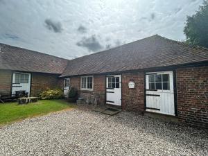 a brick house with white doors and a yard at Captains Cottage Dover in Wootton
