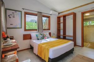a bedroom with a bed with a yellow blanket on it at Suite Villa Angelim - Barra do Cunhaú - RN in Canguaretama