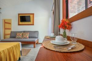 a living room with a table and a couch at Suite Villa Angelim - Barra do Cunhaú - RN in Canguaretama +20 photos