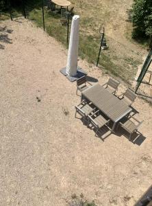 a picnic table and chairs in a field at Le Coup de Foudre Jardin - Spacieux in Sancé