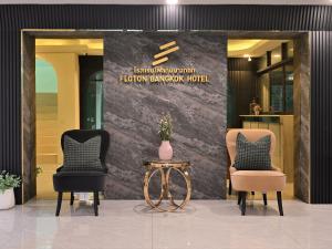 two chairs and a table in front of a lobby at Floton Bangkok Hotel in Bangkok