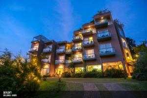 un gran edificio con muchas ventanas por la noche en Skyloft Kandy by Aaradhya, en Kandy