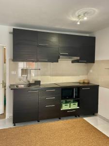 Una cocina con gabinetes negros y un fregadero. en Helen House, en Caleta de Fuste 11 fotos más