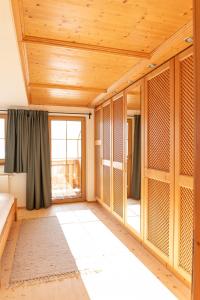 een kamer met houten plafonds en een groot raam bij Apartment Egidi in Brixen im Thale