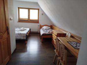 a small room with two beds and a window at Chata Koziniec przy wyciągu in Czarna Góra