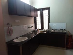 a kitchen with a sink and a counter top at Sinai Homestay in Trivandrum +27 photos