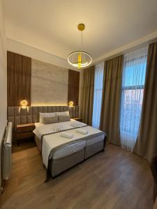 una camera da letto con un letto grande e un lampadario di Apostolovic Plus a Leskovac