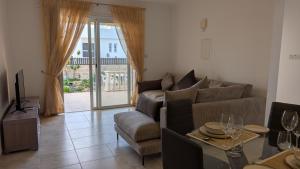 a living room with a couch and a table at St Andrews Apartment in Xylophaghou