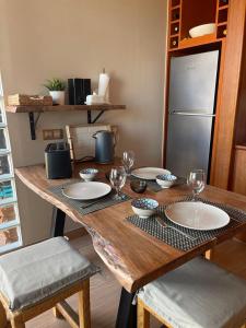 a wooden table with plates and wine glasses on it at Casa Reina in Playa Jandia