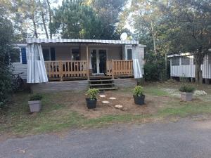 莱马特Mobil Home 40m2, Bonne Anse Siblu 4 étoiles的一座小房子,带盆栽的门廊
