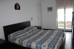 Un dormitorio con una cama con un edredón colorido. en Appartamento vista mare, en Tellaro