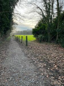 a dirt road with a fence and a field at Cosy Inn Grevenbroich in Grevenbroich