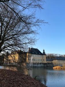 a large building sitting on the side of a river at Cosy Inn Grevenbroich in Grevenbroich