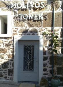 a door in a stone building with a sign above it at Molivos Tower in Mithymna