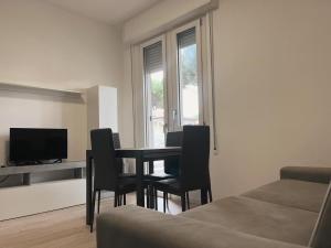 a dining room with a table and chairs and a television at Il Villino Lido Spina in Lido di Spina