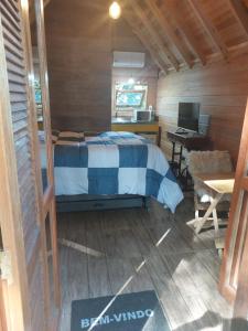 a bedroom with a bed and a desk with a computer at Cabana em gramado in Gramado