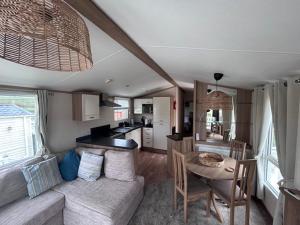 a kitchen and a living room with a couch and a table at 151 Newquay Bay Resort in Newquay Bay Resort