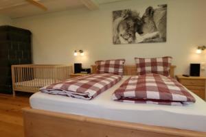 ein Schlafzimmer mit 2 Betten und einem Kinderbett in der Unterkunft Ferienhaus Lotus Hof Stallegg in Löffingen + 37 Fotos