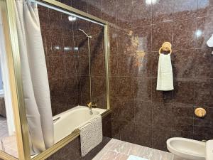 Un baño con ducha, bañera y WC. en Meloja Centro, en Hornachuelos