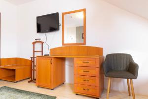 a wooden desk with a chair and a mirror at Vár Vendéglő Panzió in Sárospatak