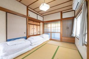 Kawatanaにある古民家民泊ーよかよーのベッドが3つと窓のある部屋