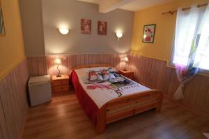 a bedroom with a bed and two lamps on two tables at Auberge du Col de Neronne in Le Falgoux