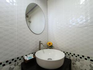a bathroom with a white sink and a mirror at Cherlyn Homestay เฌอลินน์โฮมสเตย์ เกาะลิบง in Ban Batubute
