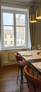a dining room table with chairs and a large window at Appartement T3 centre ville avec 1 Parking in Dinan +36 photos