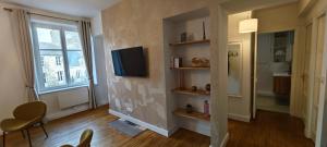 a living room with a tv on a wall at Appartement T3 centre ville avec 1 Parking in Dinan