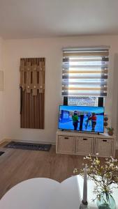 a living room with a flat screen tv and a window at Ferienhaus Roßbachtal in Biberschlag +33 photos