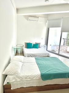 two beds in a white room with a window at Apartamento Vacacional San Jerónimo in Medellín +24 photos
