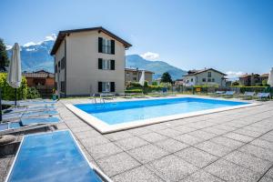 a swimming pool in front of a house with mountains at My Holidays New Eden Mansarda in Domaso +10 photos