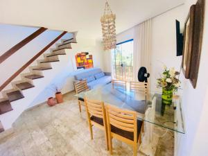 a dining room with a glass table and a blue couch at Villaggio Orizzonte in Salvador