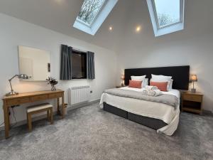 a bedroom with a bed and a desk and window at Fishers View, Castle Approach, Tregenna Castle in St Ives +71 photos