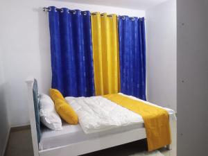 Cama pequeña con cortina amarilla y azul en Garden court, en Kitengela 